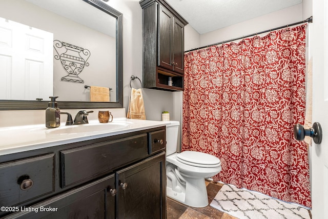 bathroom featuring a textured ceiling, toilet, and vanity