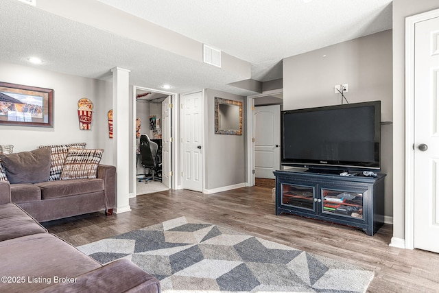 living room with a textured ceiling and hardwood / wood-style flooring