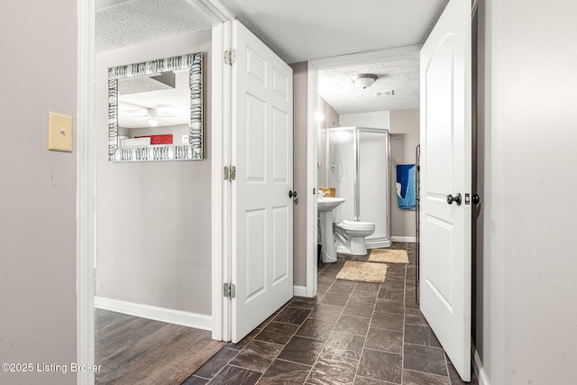 hallway with a textured ceiling and sink