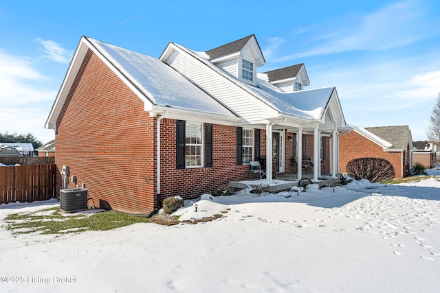 new england style home with covered porch and central AC