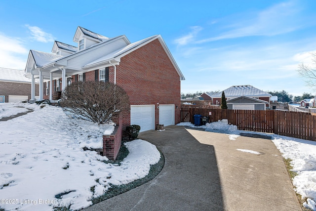 snow covered property with a garage