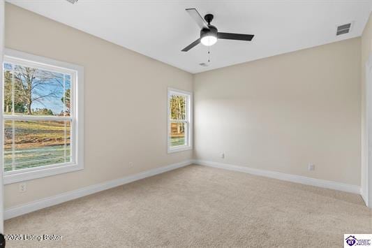 carpeted empty room with ceiling fan and a healthy amount of sunlight