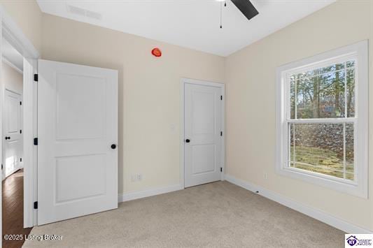 unfurnished bedroom with light colored carpet and ceiling fan