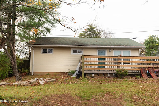 back of property with a yard and a wooden deck