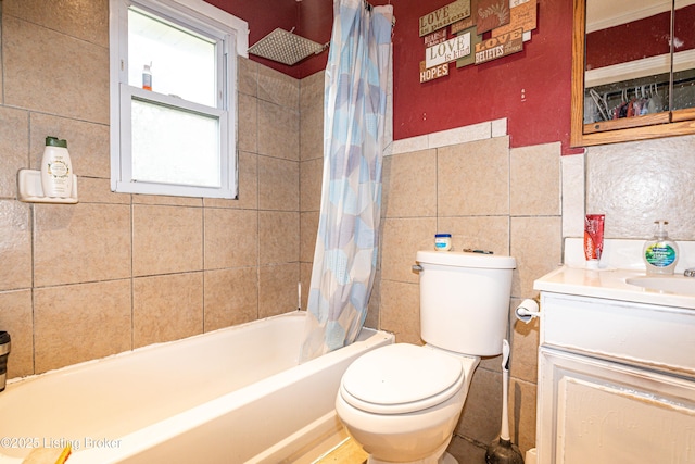 full bathroom featuring shower / tub combo, vanity, tile walls, and toilet