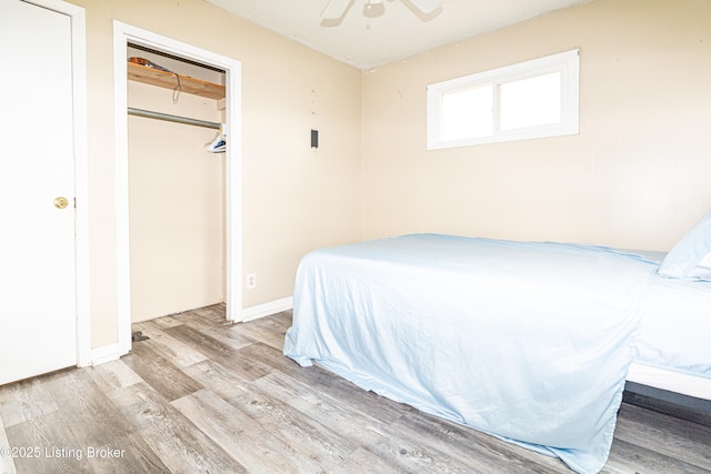 bedroom with ceiling fan, light wood-type flooring, and a closet