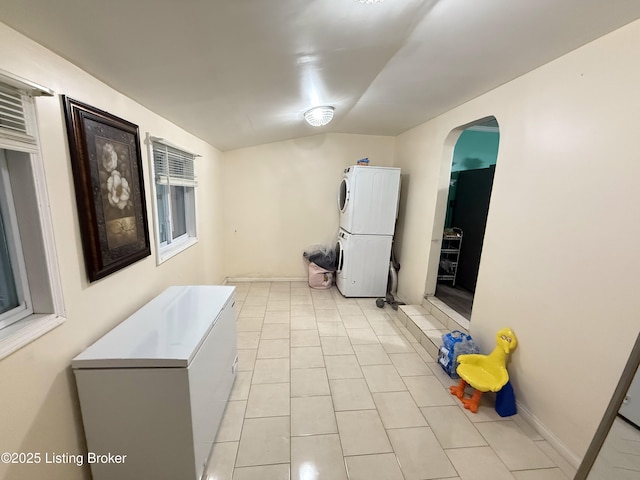 kitchen with light tile patterned floors and stacked washer and clothes dryer