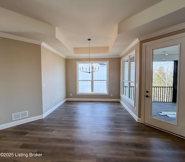 unfurnished dining area with dark hardwood / wood-style flooring, a tray ceiling, and a notable chandelier