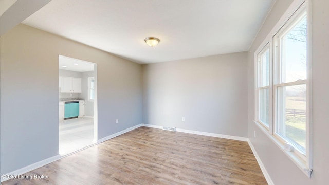 empty room with light hardwood / wood-style flooring and a healthy amount of sunlight