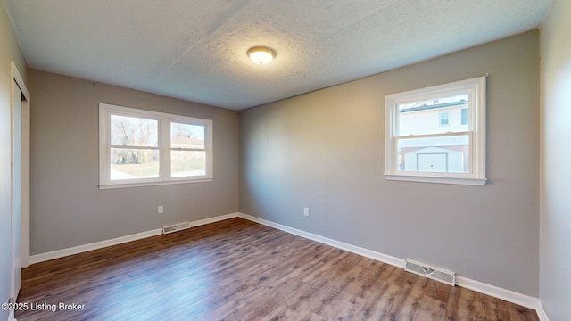 empty room featuring hardwood / wood-style flooring and a textured ceiling