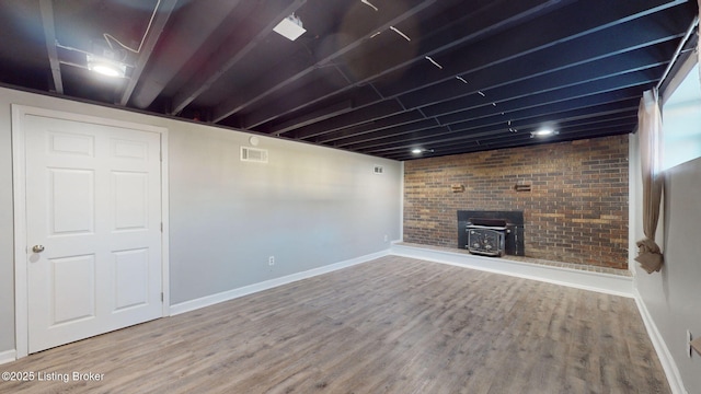 basement with hardwood / wood-style flooring and a wood stove