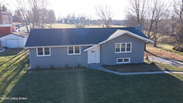 view of front of house featuring a front yard and an outbuilding