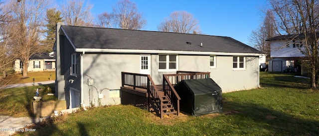 back of house with a wooden deck, a garage, and a lawn