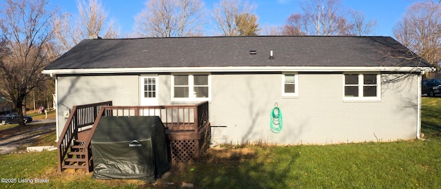 rear view of house with a lawn and a wooden deck