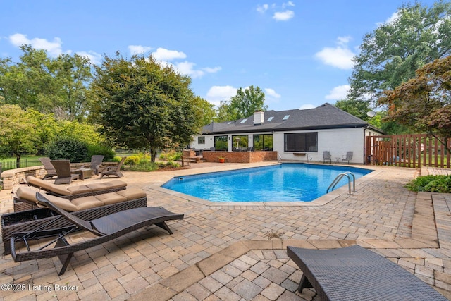 pool with a patio and fence