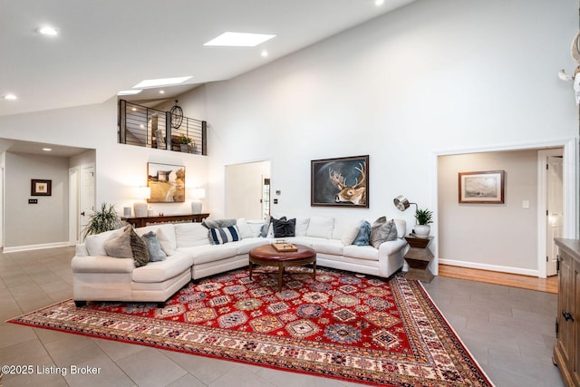 tiled living room with high vaulted ceiling, recessed lighting, a skylight, and baseboards