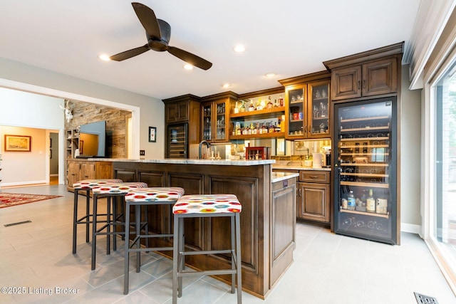 bar featuring ceiling fan, wine cooler, indoor wet bar, and visible vents