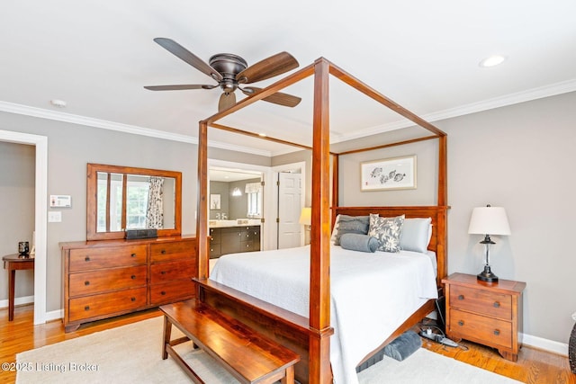 bedroom with crown molding, light wood-style flooring, ensuite bathroom, ceiling fan, and baseboards