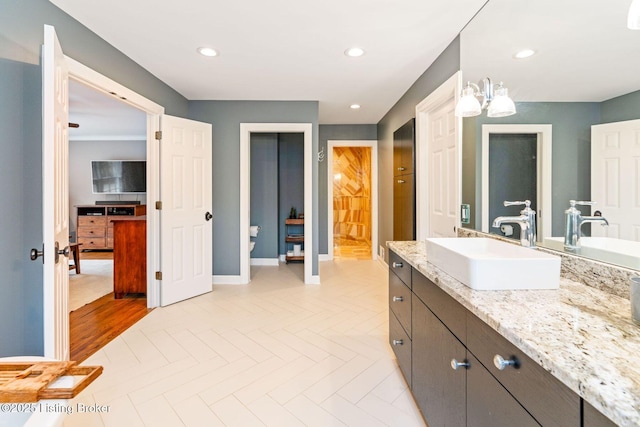 bathroom featuring baseboards, vanity, and recessed lighting