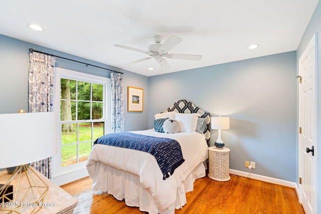 bedroom featuring recessed lighting, multiple windows, baseboards, and wood finished floors