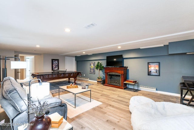 living room with light wood-type flooring, baseboards, a fireplace, and visible vents