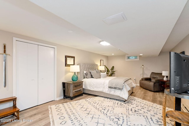 bedroom featuring light wood finished floors, a closet, and baseboards