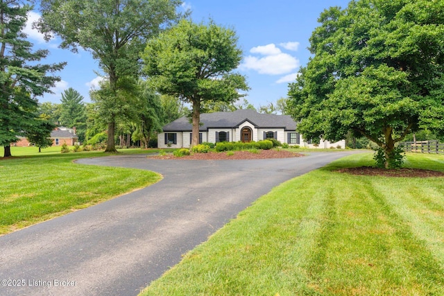 view of front of home featuring aphalt driveway and a front yard