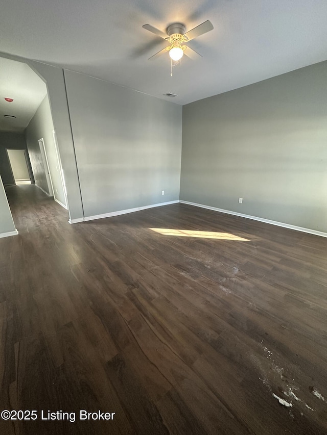 unfurnished room featuring ceiling fan and dark wood-type flooring