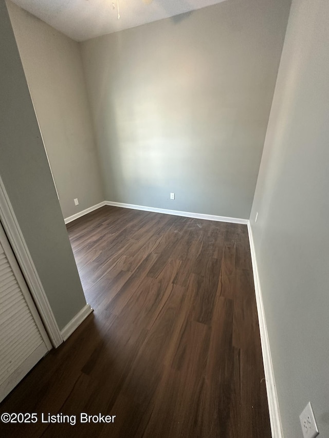 empty room featuring ceiling fan and dark wood-type flooring