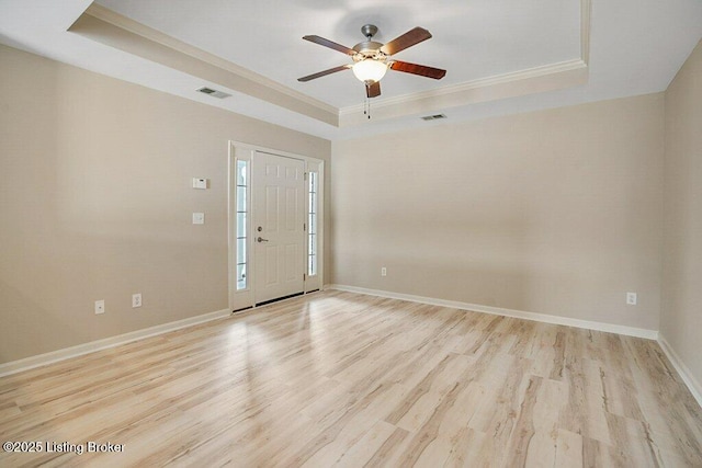 entrance foyer with a raised ceiling, ceiling fan, light hardwood / wood-style floors, and ornamental molding