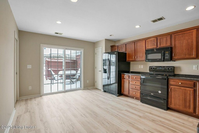 kitchen with black appliances and light hardwood / wood-style flooring