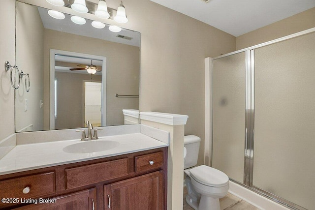 bathroom featuring ceiling fan, hardwood / wood-style floors, toilet, a shower with door, and vanity