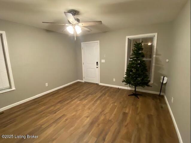 unfurnished room featuring ceiling fan and dark wood-type flooring