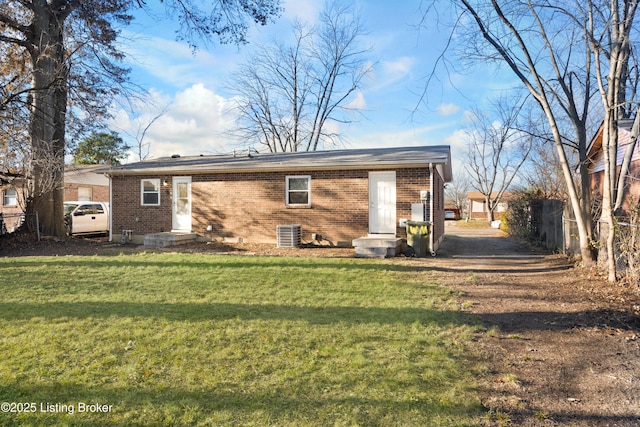 rear view of property with a lawn and cooling unit