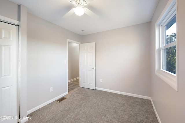 unfurnished bedroom with ceiling fan, carpet floors, and a closet