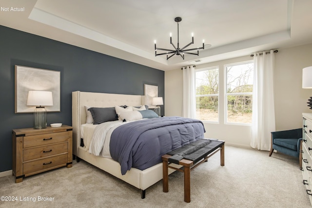 bedroom featuring an inviting chandelier, light carpet, and a tray ceiling