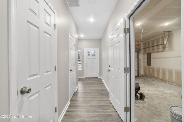 doorway with electric panel and hardwood / wood-style flooring