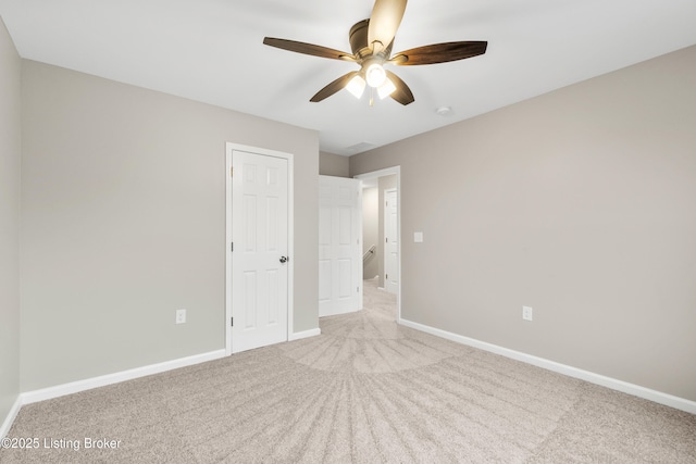 unfurnished bedroom with light colored carpet and ceiling fan