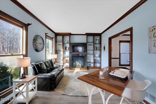 living room with ornamental molding and light hardwood / wood-style flooring