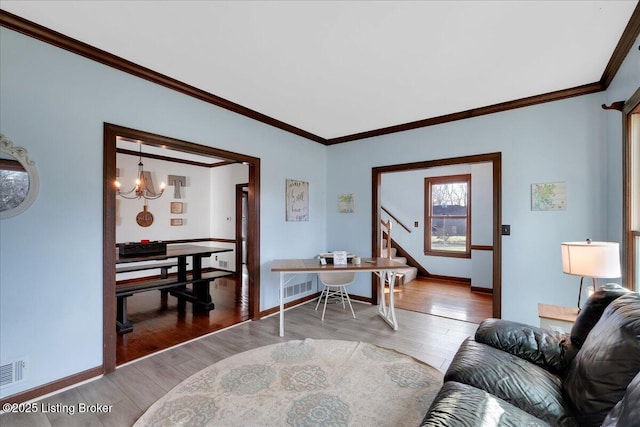 living room featuring ornamental molding, hardwood / wood-style flooring, and a notable chandelier