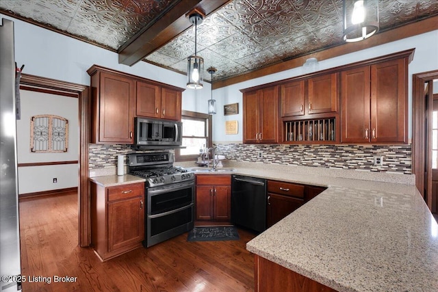 kitchen featuring light stone countertops, sink, stainless steel appliances, dark hardwood / wood-style floors, and decorative light fixtures