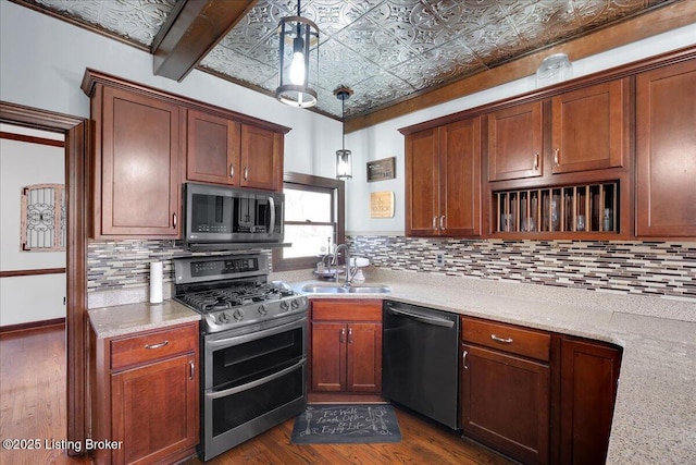 kitchen featuring appliances with stainless steel finishes, backsplash, sink, beam ceiling, and decorative light fixtures