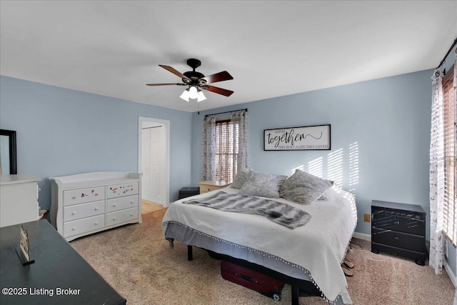 bedroom featuring a closet, light colored carpet, and ceiling fan