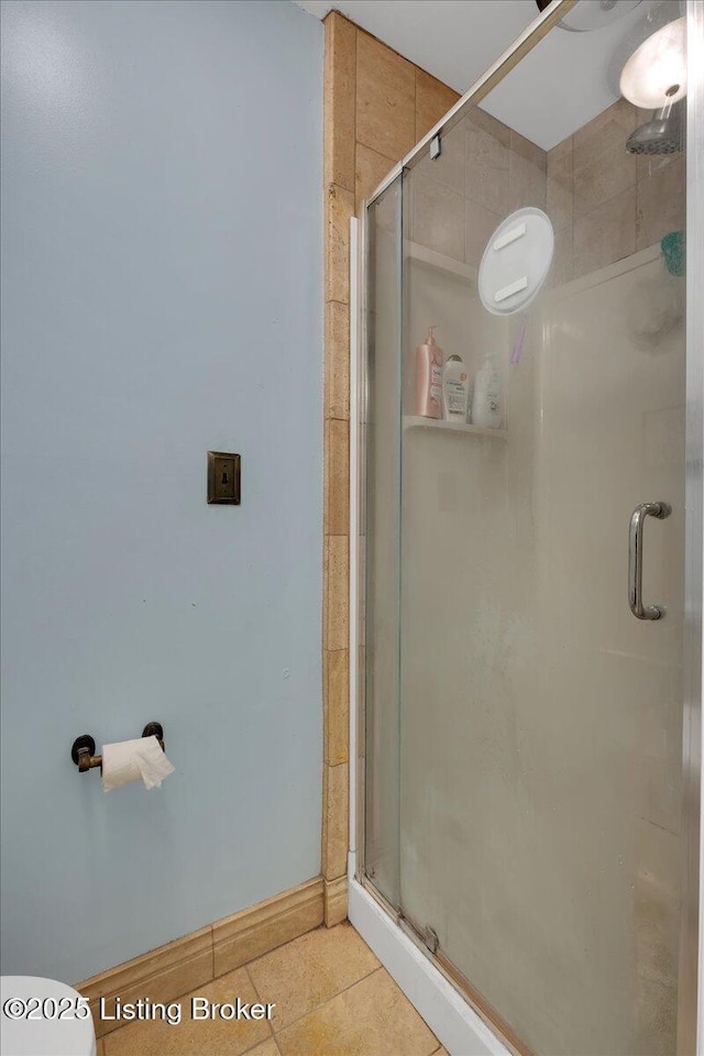 bathroom with tile patterned floors, toilet, and walk in shower