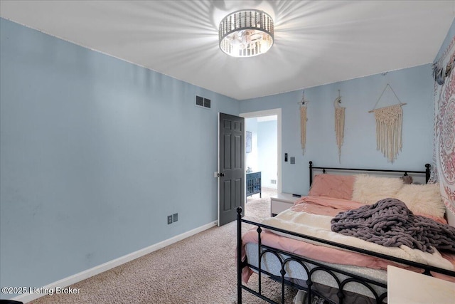 carpeted bedroom with an inviting chandelier