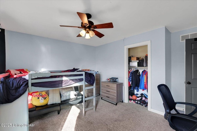 carpeted bedroom featuring ceiling fan and a closet