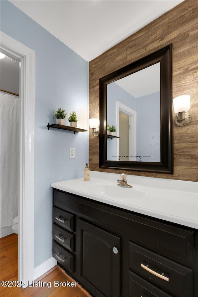 bathroom with vanity, toilet, and wood-type flooring