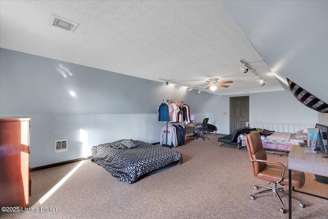 carpeted bedroom featuring a textured ceiling, rail lighting, ceiling fan, and lofted ceiling