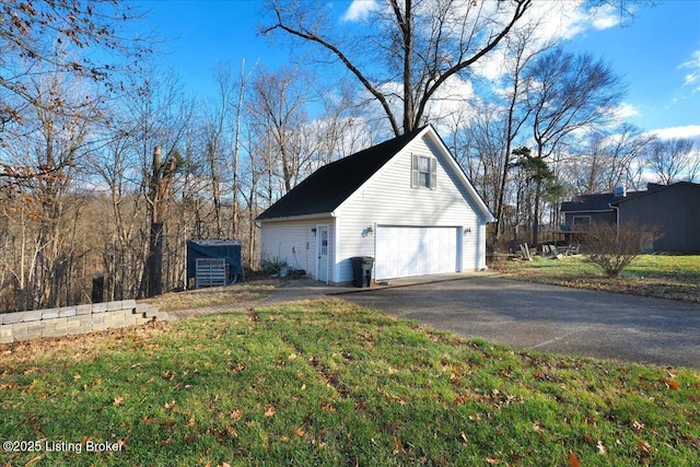 view of side of property with a garage, an outdoor structure, and a yard