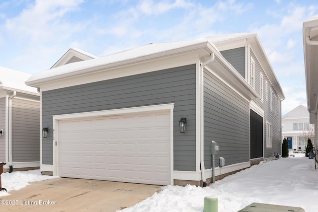 view of snow covered exterior with a garage